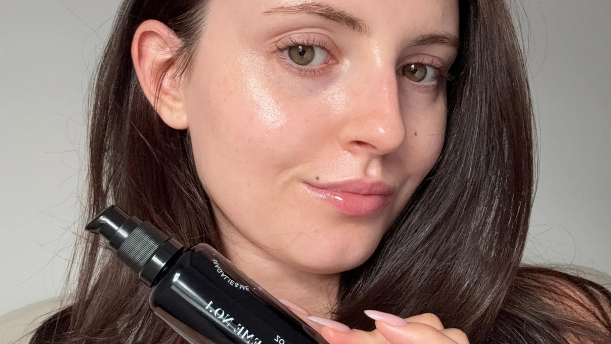 Woman with glowing skin holding a Magalie&ME bottle