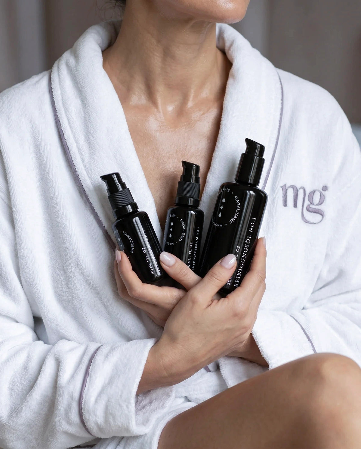 Woman in a white robe holding her Magalie&ME skincare routine