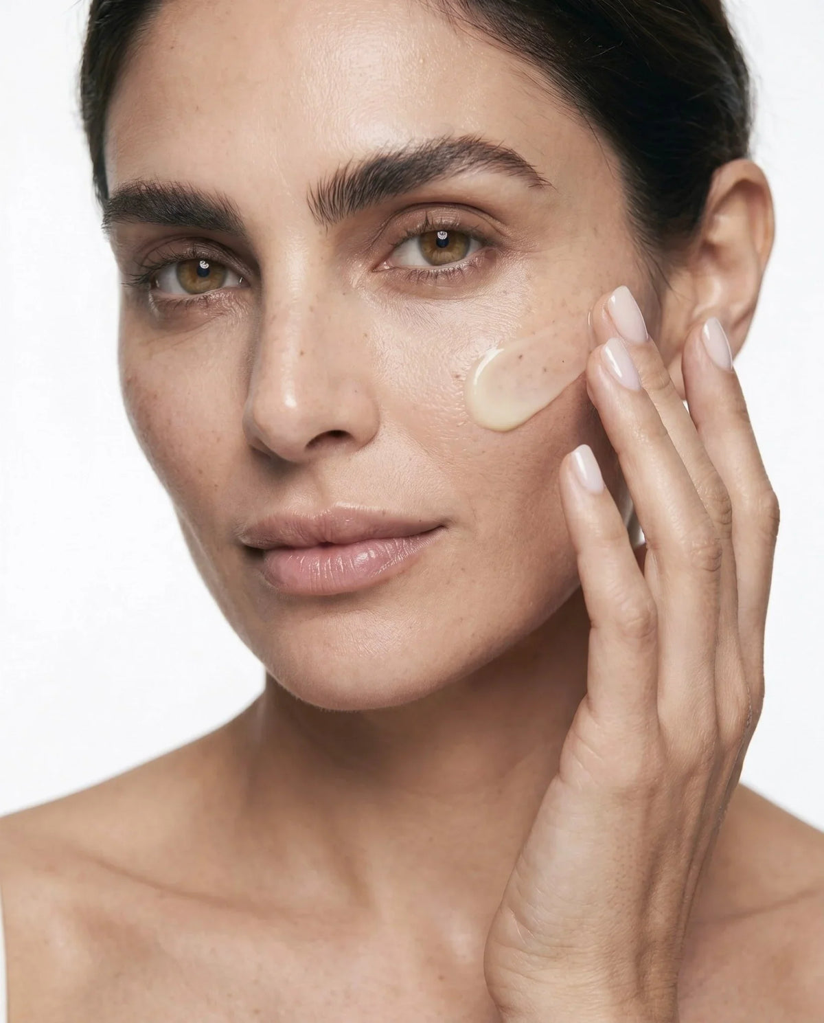 Woman applying Intensive Renewal Serum No. 1 to her cheek