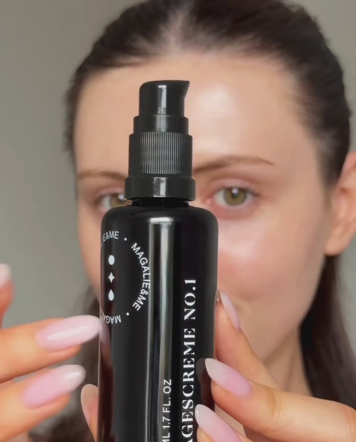Woman holding Regenerating Day Cream No. 1 up to the camera